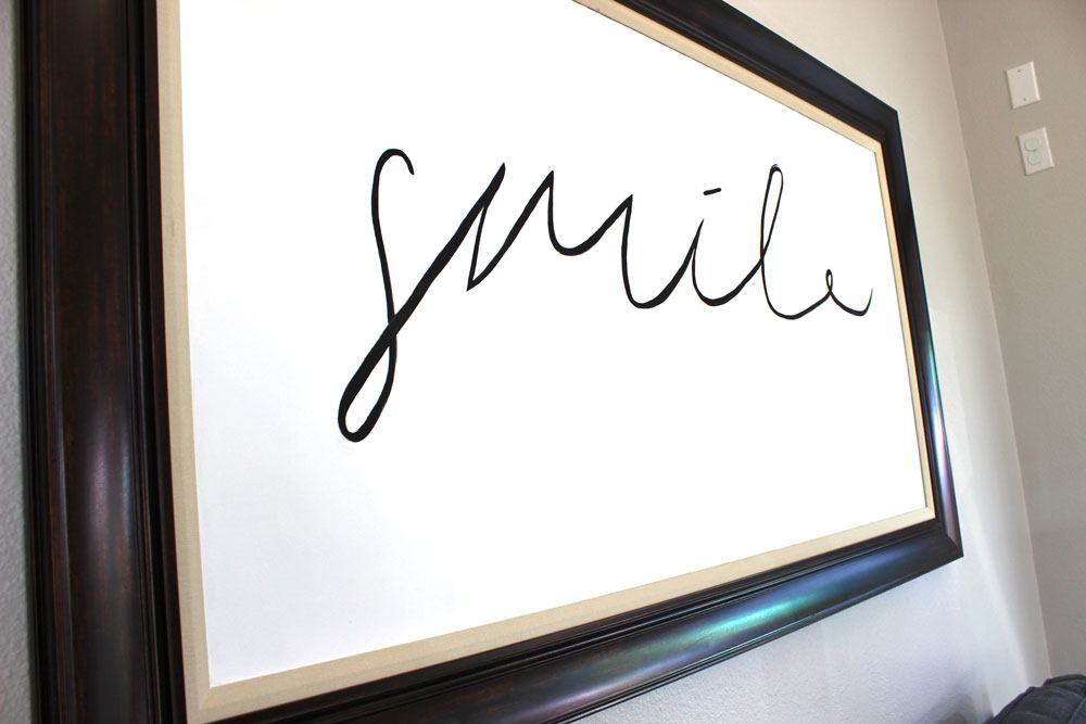 portrait of the word smile hanging on a wall